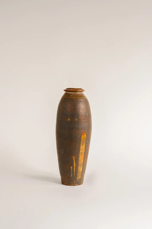 Bottiglia di Katherine, un manufatto in ceramica realizzato dal ceramista Maurizio Gualdi, anche noto come Cono9. L'opera è realizzata al tornio e ha una doppia smaltatura: la prima con smalto tenmoku e la seconda shino